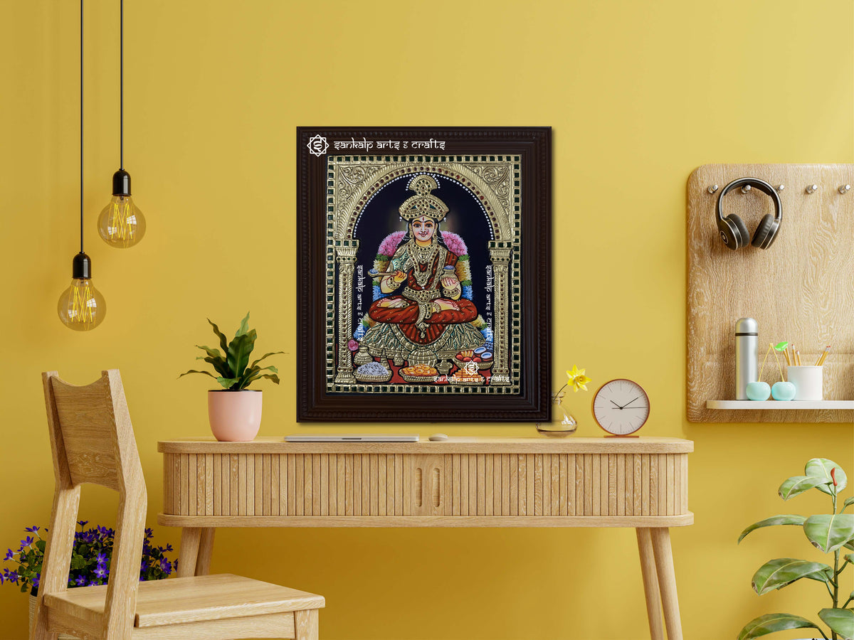 A framed Annapoorani Tanjore painting showing the goddess seated in a divine pose, exuding spirituality and abundance with intricate gold work and stunning craftsmanship.