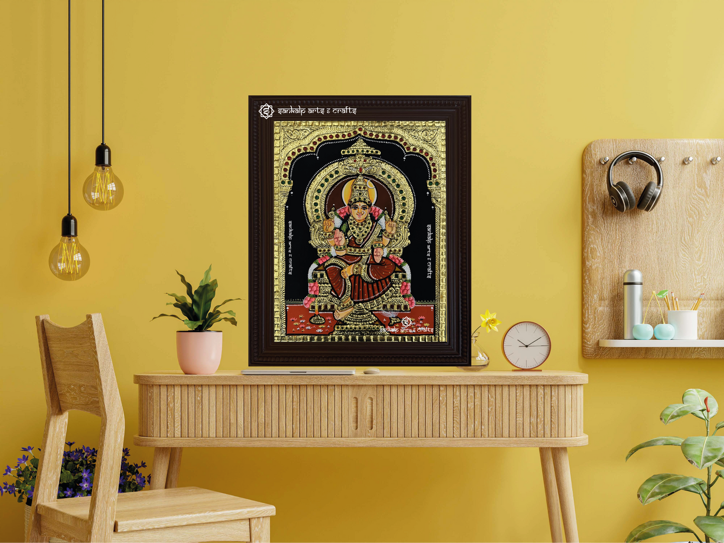 A framed Bhuvaneshwari Tanjore painting displayed as a wall hanging, radiating divine energy with its rich textures, vivid colors, and exquisite gold work.