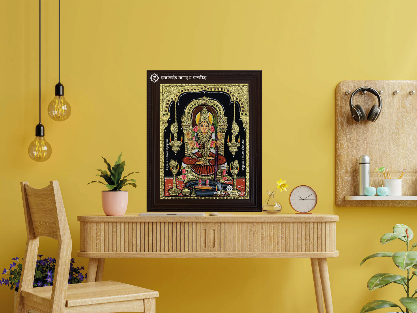 A framed Kamakshi Amman Tanjore painting displayed as a wall hanging, enhancing the room with its divine presence, intricate detailing, and traditional gold work.