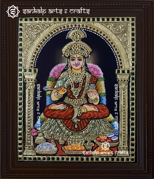 A beautifully handcrafted Annapoorani Tanjore painting depicting the goddess seated gracefully, holding a vessel of food, adorned with intricate gold foil detailing and rich traditional colors.

