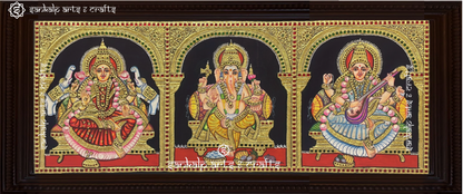 A beautifully handcrafted antique-style Tanjore painting featuring Lord Ganesha, Goddess Lakshmi, and Goddess Saraswathi in a single panel, adorned with intricate gold foil detailing and rich traditional colors, perfect for pooja rooms.

