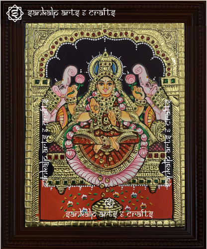 A beautifully framed Tanjore painting of Goddess Gajalakshmi, seated on a lotus with elephants showering blessings. A perfect decor piece for homes in Chennai & Bangalore.