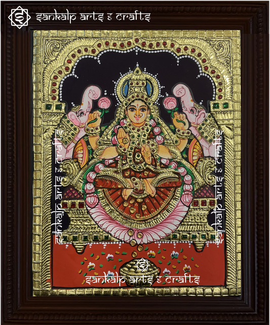 A beautifully framed Tanjore painting of Goddess Gajalakshmi, seated on a lotus with elephants showering blessings. A perfect decor piece for homes in Chennai & Bangalore.