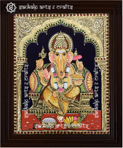 A close-up of the Ganesha Tanjore painting showcasing Lord Ganesha holding his sacred symbols, embellished with gold detailing and rich hues, symbolizing wisdom, prosperity, and success.

