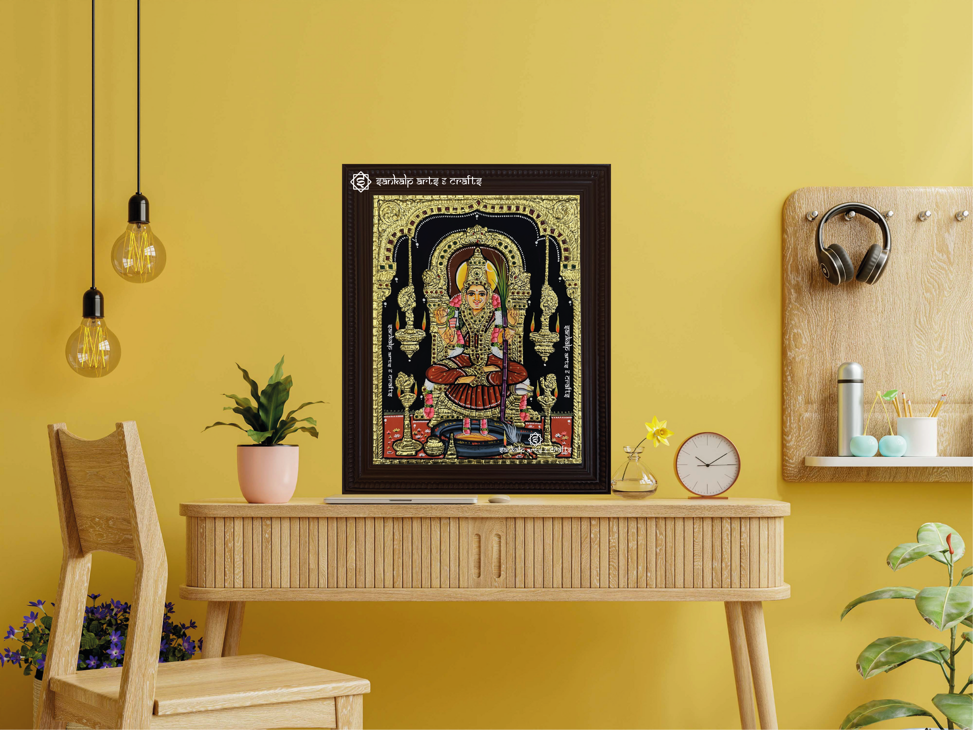 A framed Kamakshi Amman Tanjore painting displayed as a wall hanging, enhancing the room with its divine presence, intricate detailing, and traditional gold work.
