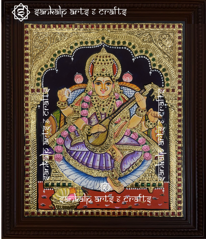A beautifully handcrafted Saraswati Tanjore painting depicting Goddess Saraswati, the goddess of knowledge and wisdom, playing the veena. The painting is adorned with intricate gold foil detailing and vibrant colors, capturing her divine grace and wisdom.