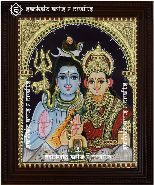 A beautifully framed Tanjore painting of Lord Shiva and Goddess Parvathi, adorned with intricate gold foil detailing. A perfect decor piece for homes in Chennai & Bangalore.

